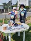 Isabelle et Kévin (association Vivre en Transition), référents du site de compostage au jardin partagé du quartier du Ramponneau à Fécamp (76), devant leur table d'animation avec des bioseaux recyclés.
